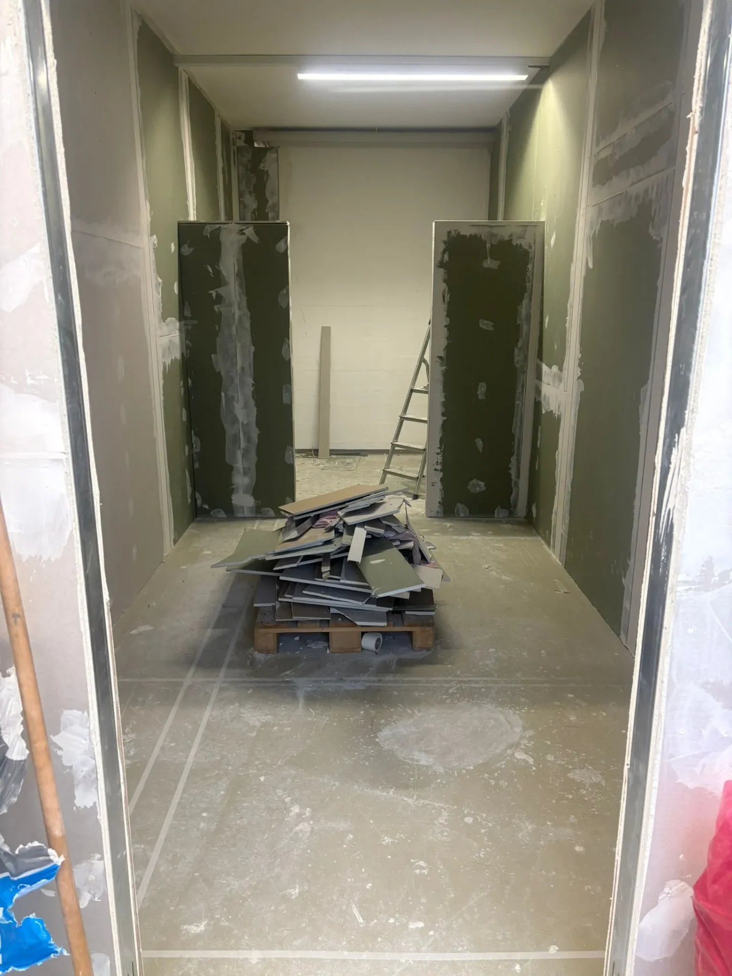 Trockenbau-Baustelle mit aufgestellten Gipsplatten und Material